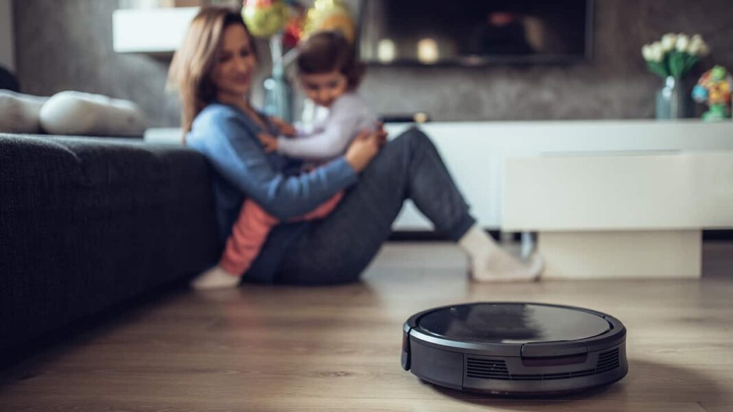 mother and child in room with robot vacuum