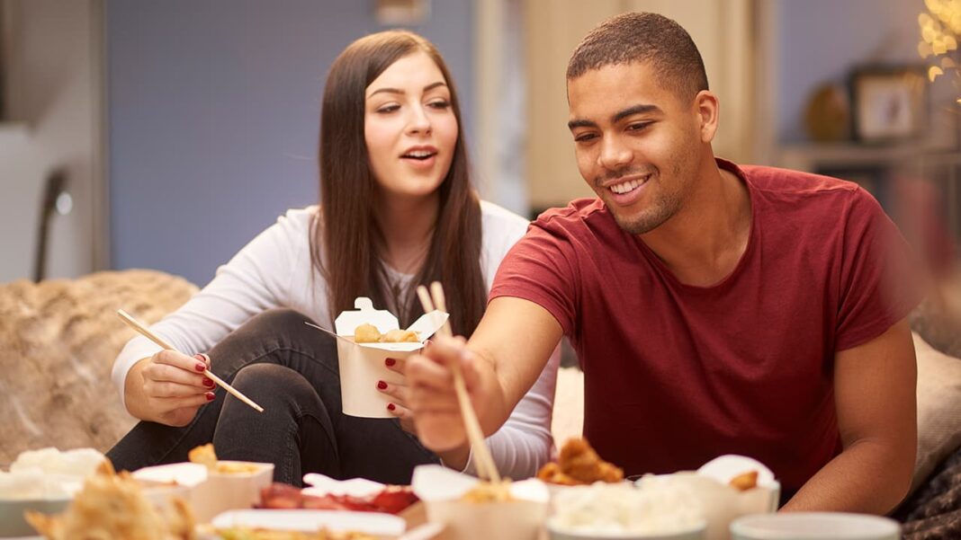 iStock-sturti man woman eating chinese food at home takeout