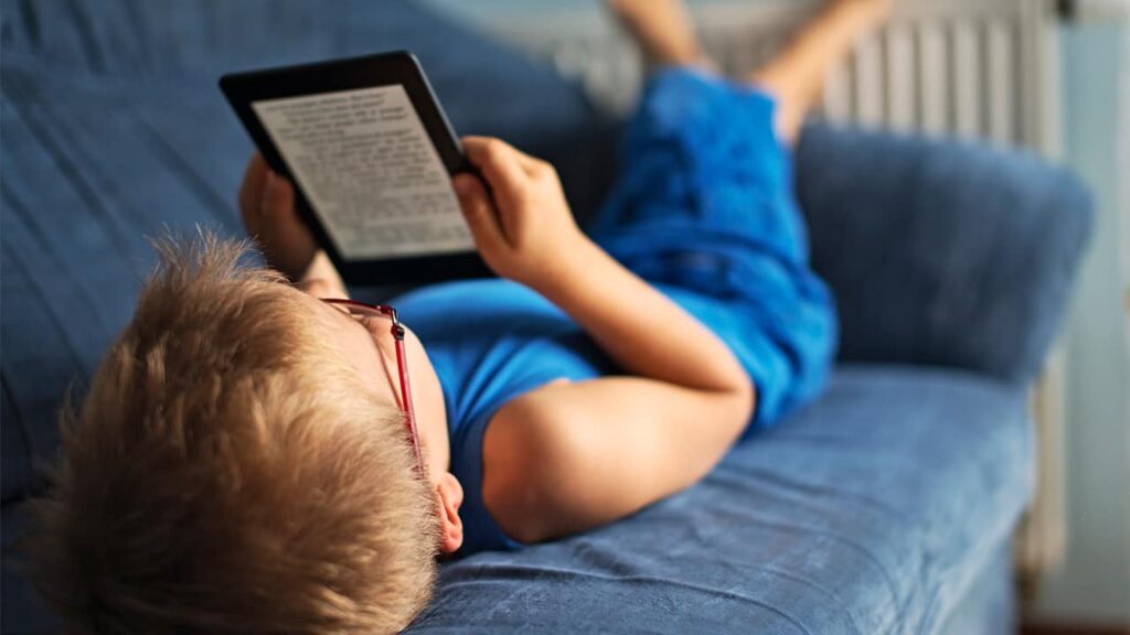 Boy on a couch reading a kindle