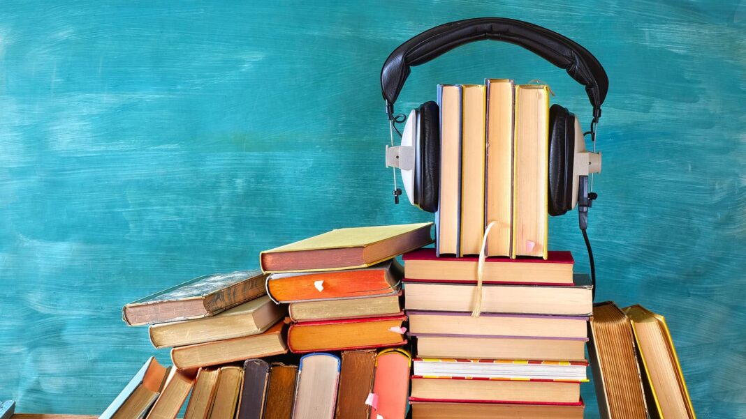 Audio book audible hero headphones on books in front of chalk board