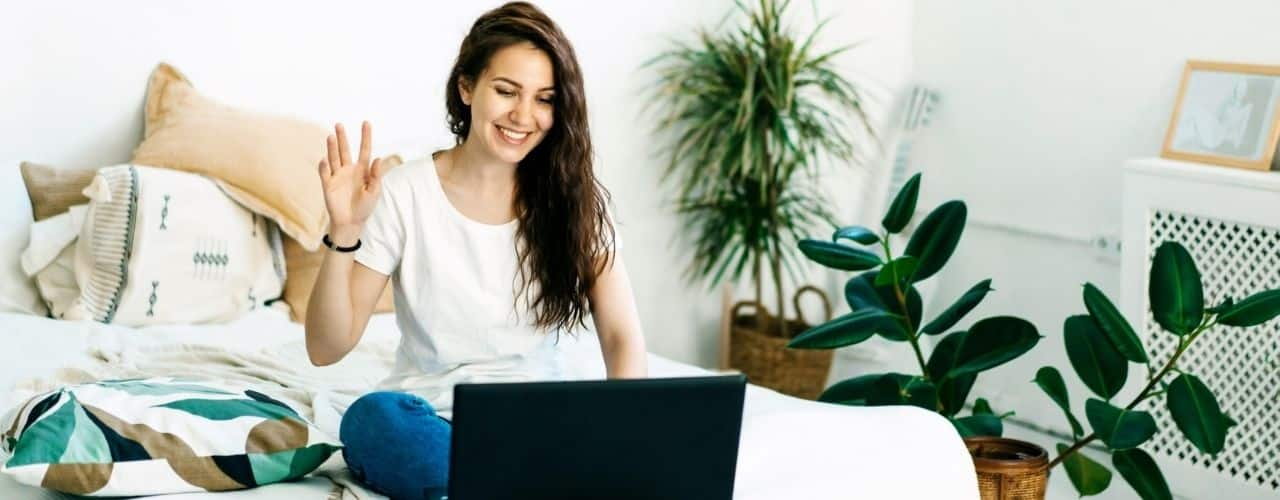 woman waving during a laptop video call