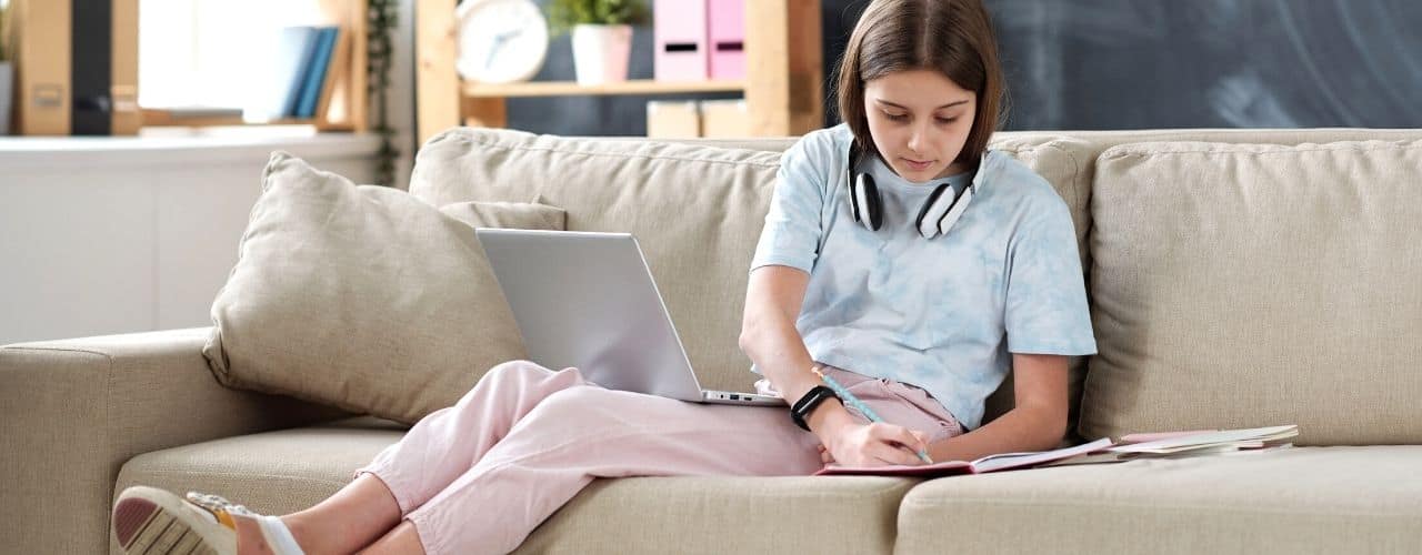 girl doing homework on couch