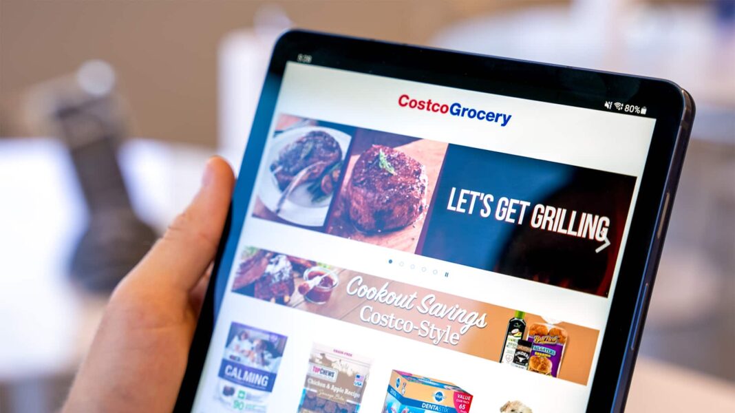 man holding tablet looking at costco grocery website tab s7 slickdeals