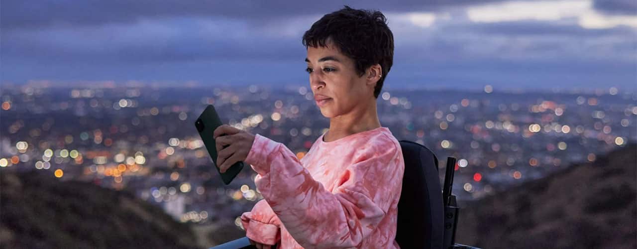 google pixel 5a held by woman with city behind her