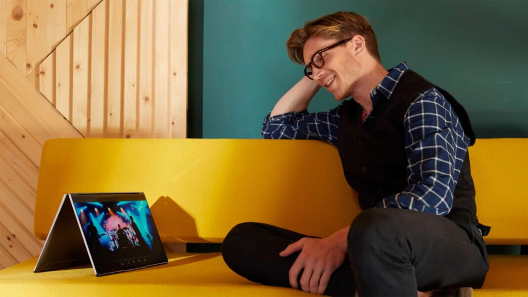 man wearing glasses looking at Lenovo Yoga 9i 14 2-in-1 Touch-Screen Laptop hero