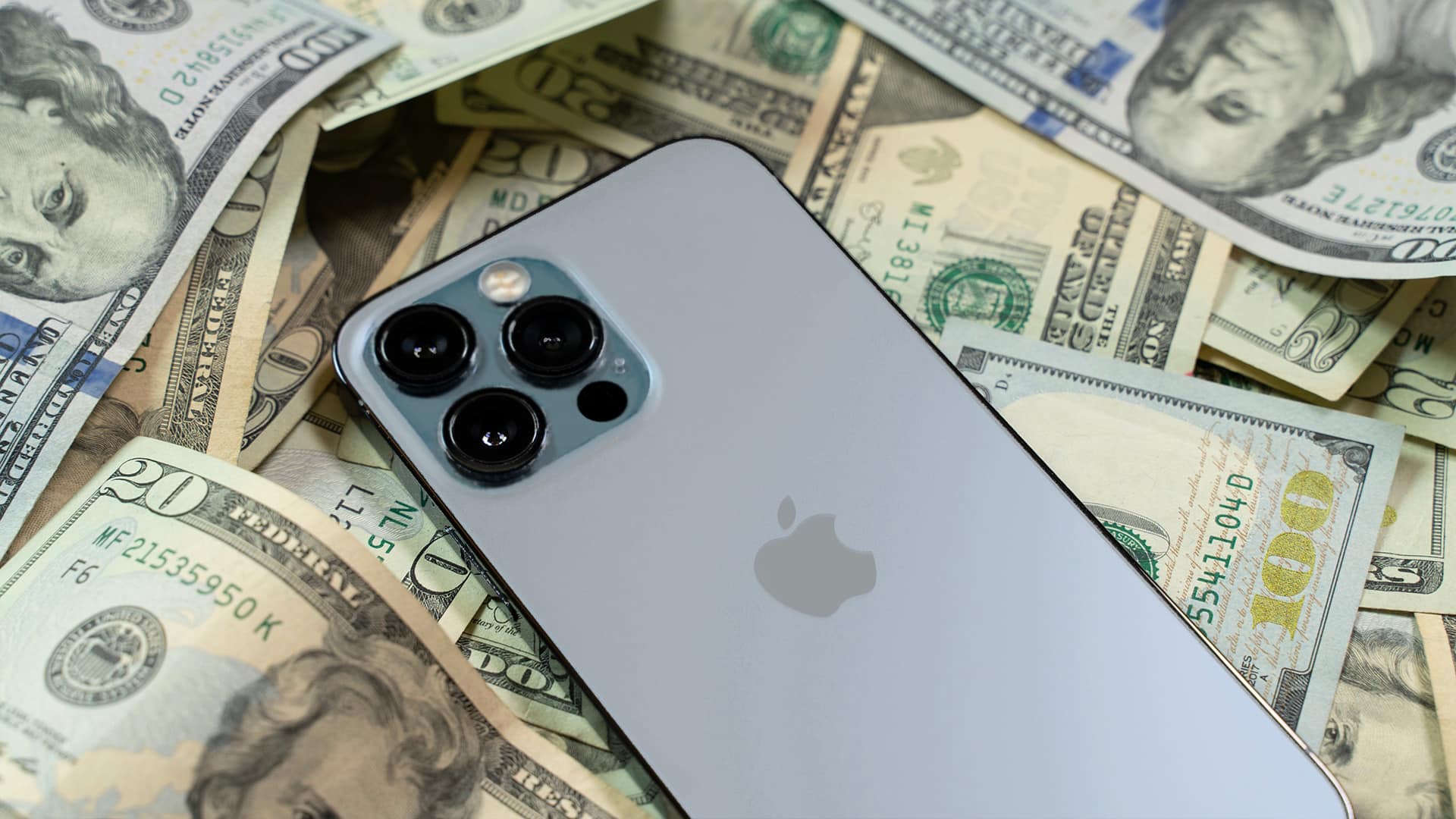 iphone 13 pro sitting on top of money technology money devices