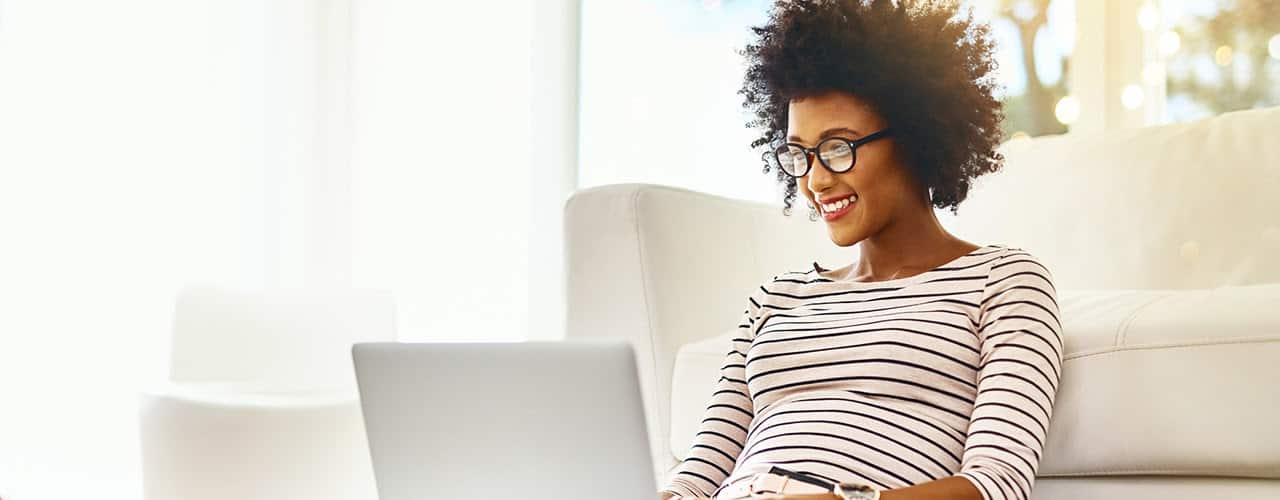 woman using laptop inbody istock on white background leaning against couch