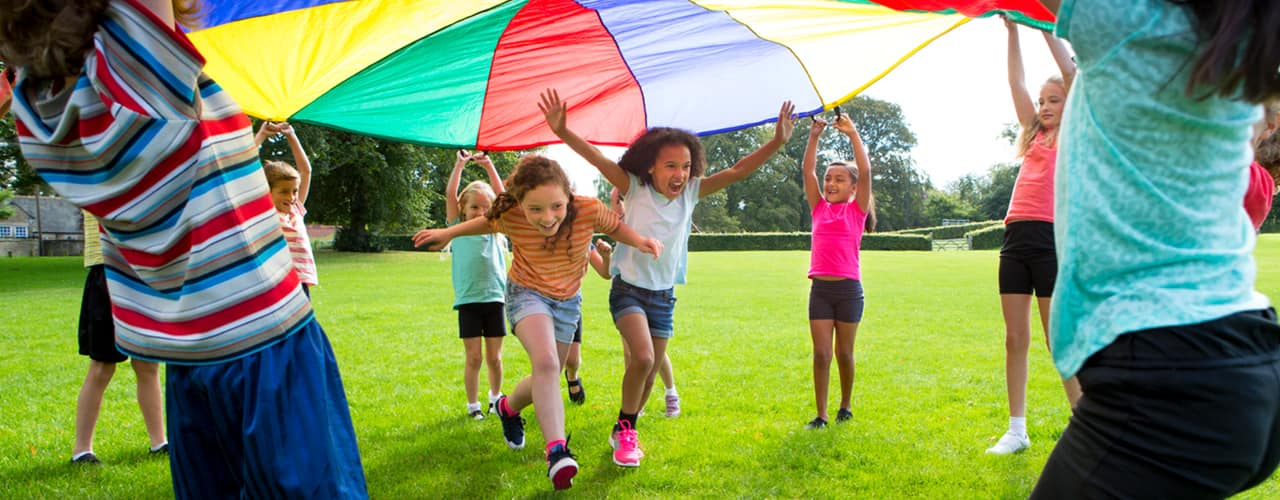 school age children playing with parachute