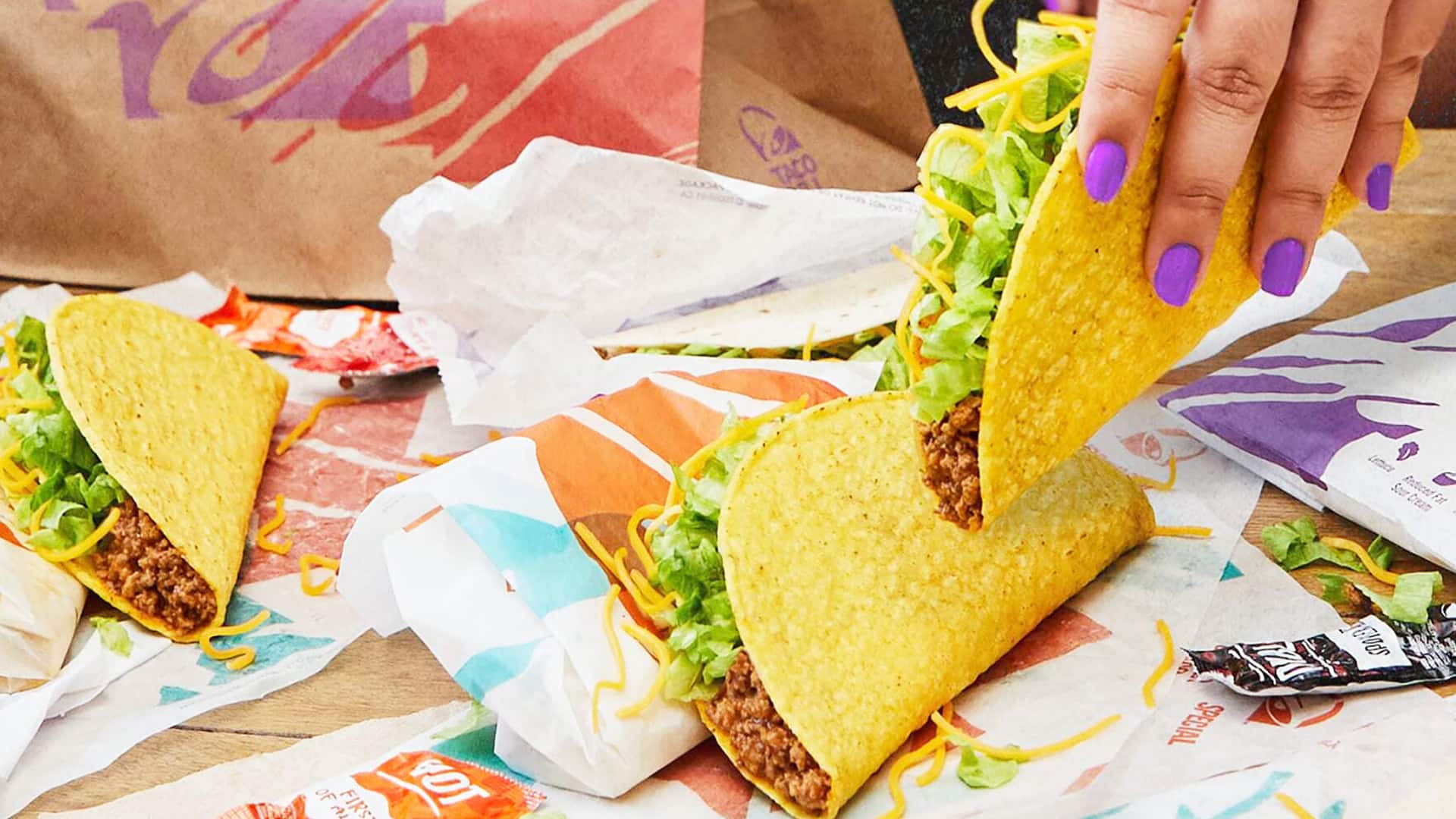 womans hand eating tacos