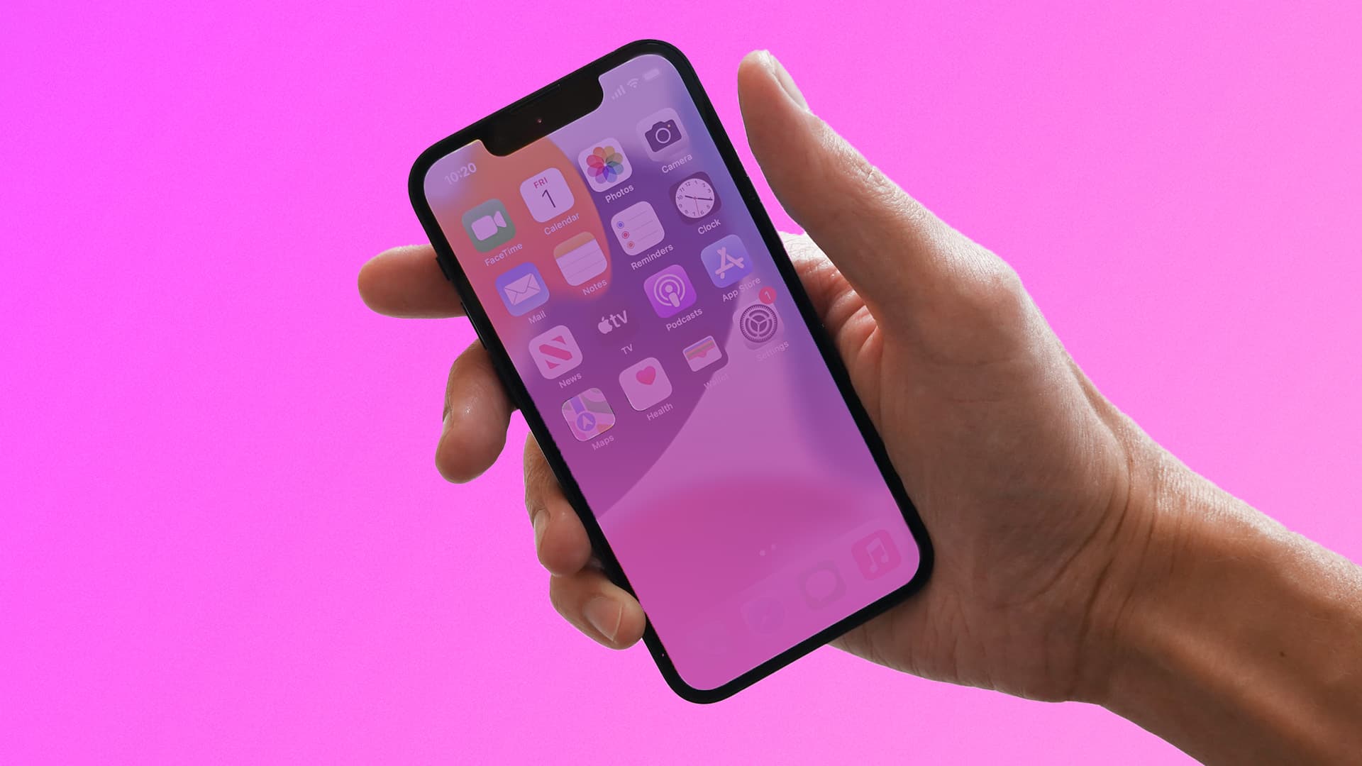 iphone 13 mini in hand with pink overlay on pink background