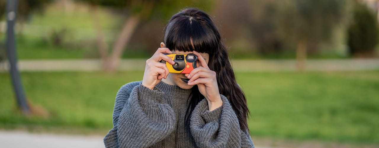 woman using disposable film camera 