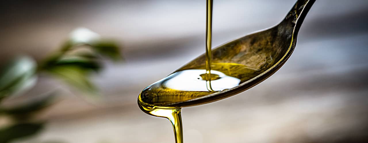 olive oil dripping off a spoon