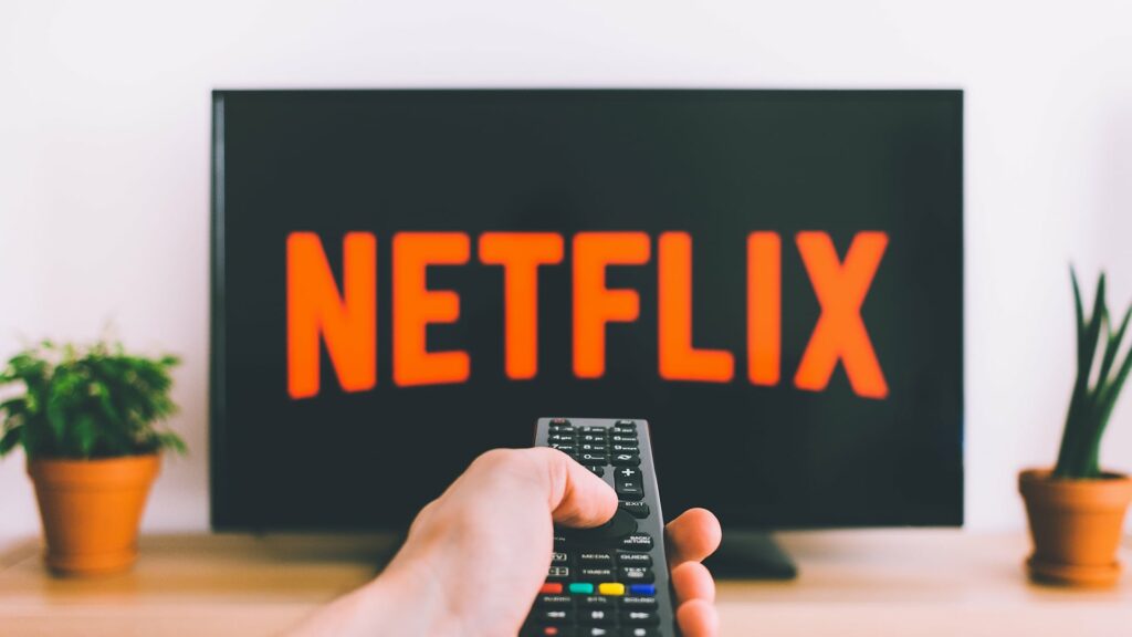 hand selecting netflix with remote