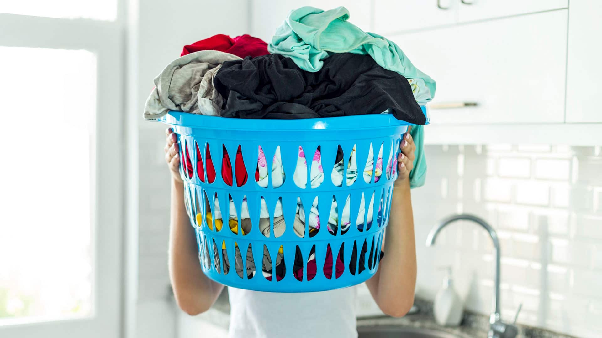 woman holding laundry basket in laundry machine