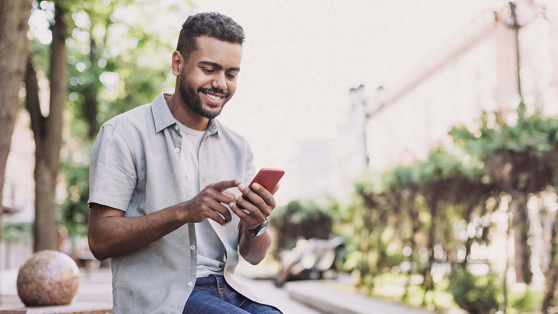 man smiling and using cell phone