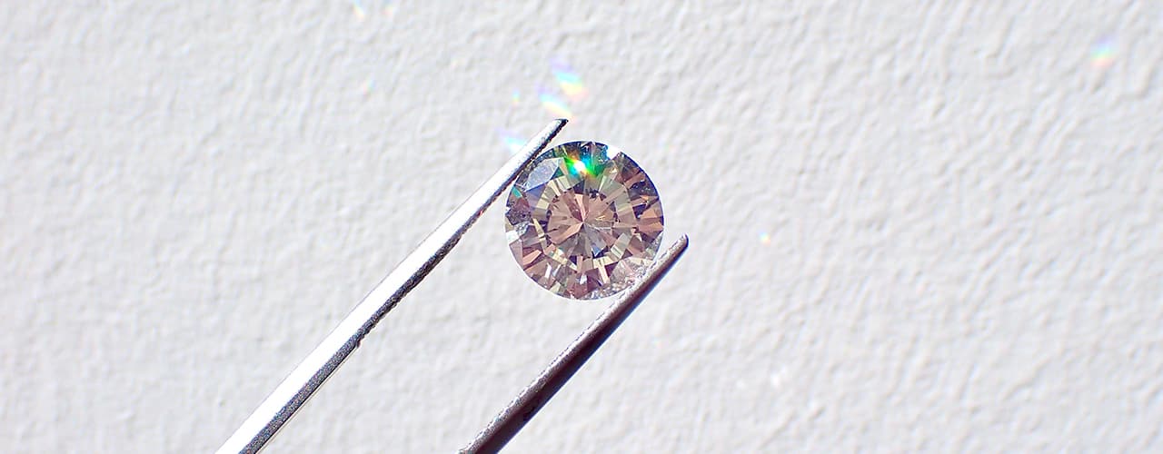 diamond in tweezers for inspection