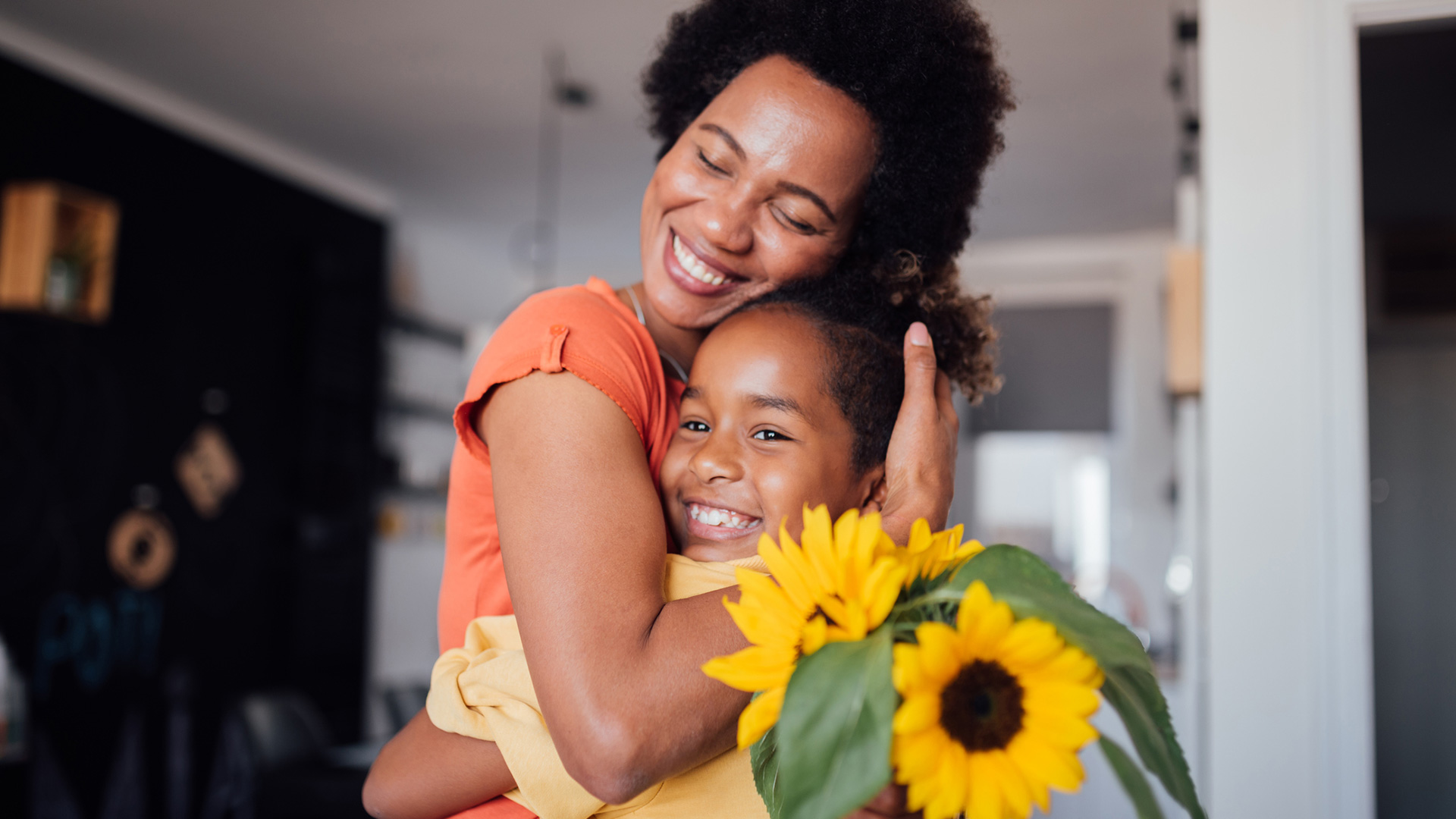 girl hugging mom with sunflowers