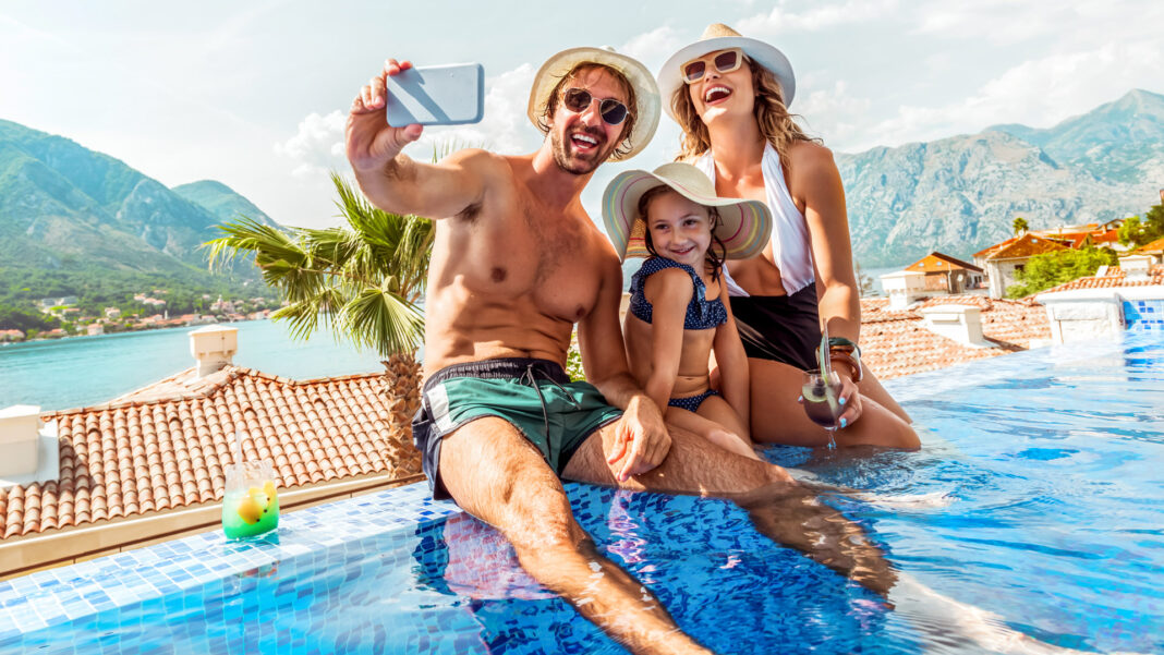 Family in pool on vacation taking selfie