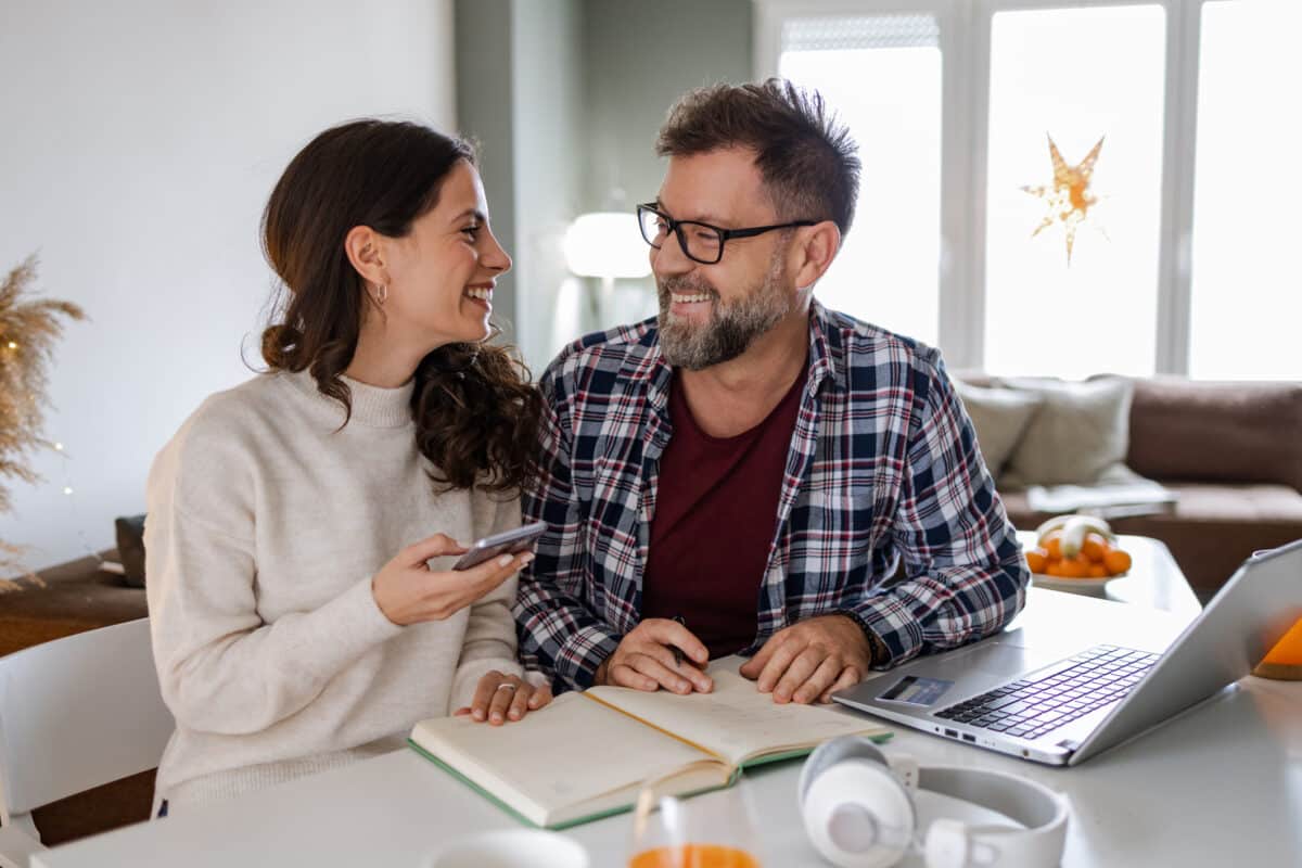 Married couple making a list and shopping online.