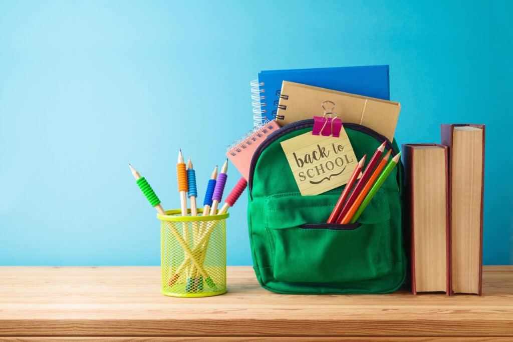 Backpack, books, and school supplies on a table