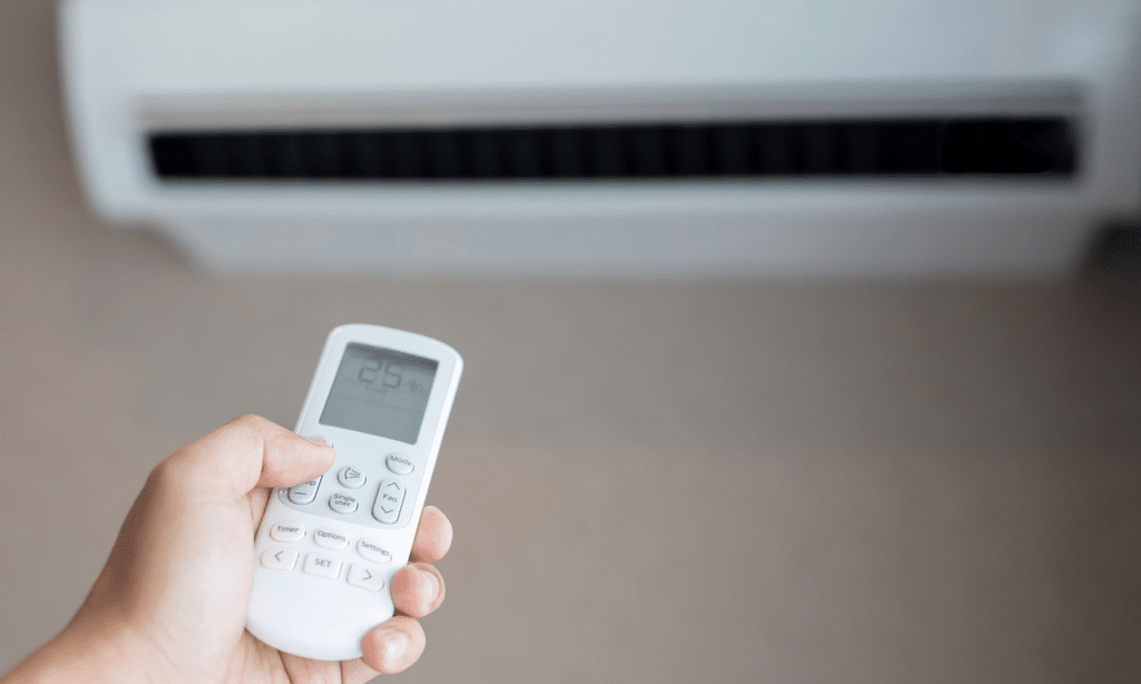 AC wall unit with a hand holding remote