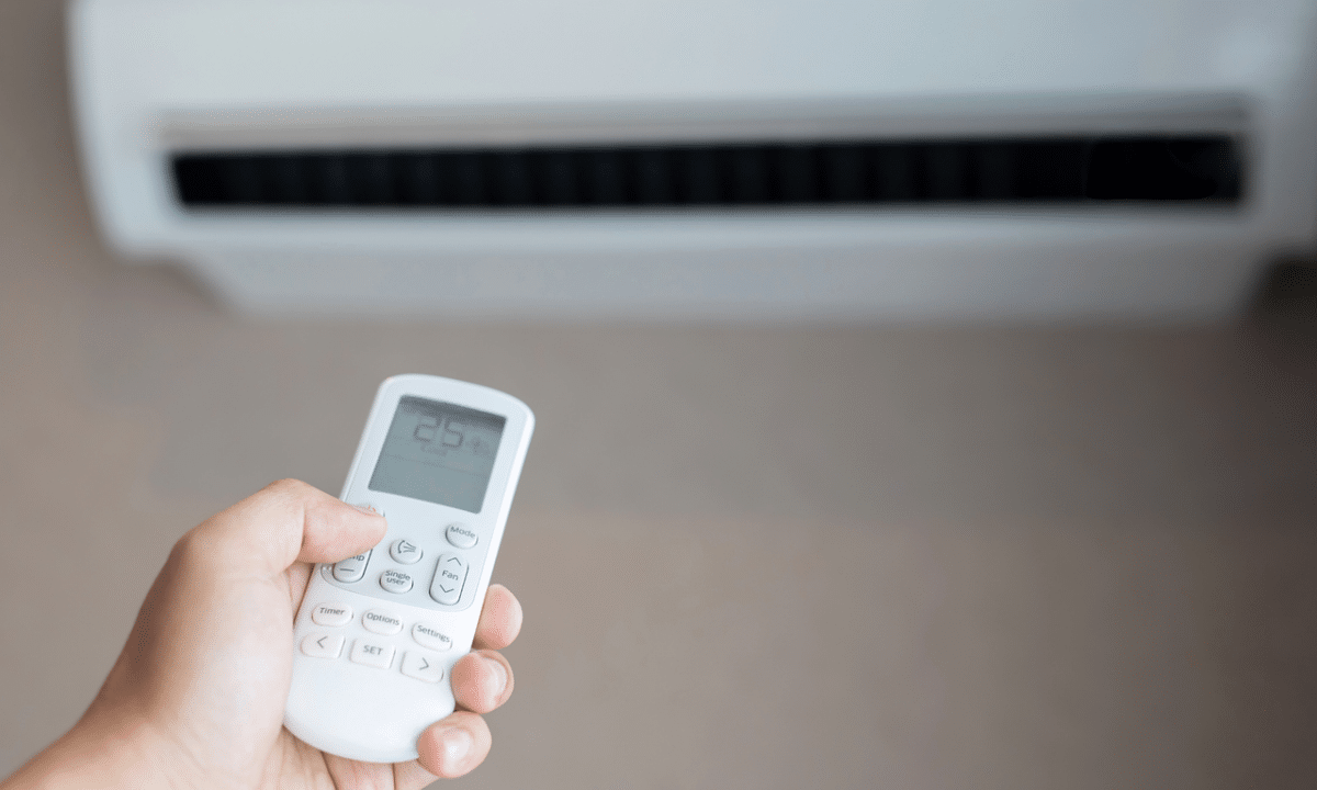AC wall unit with a hand holding remote