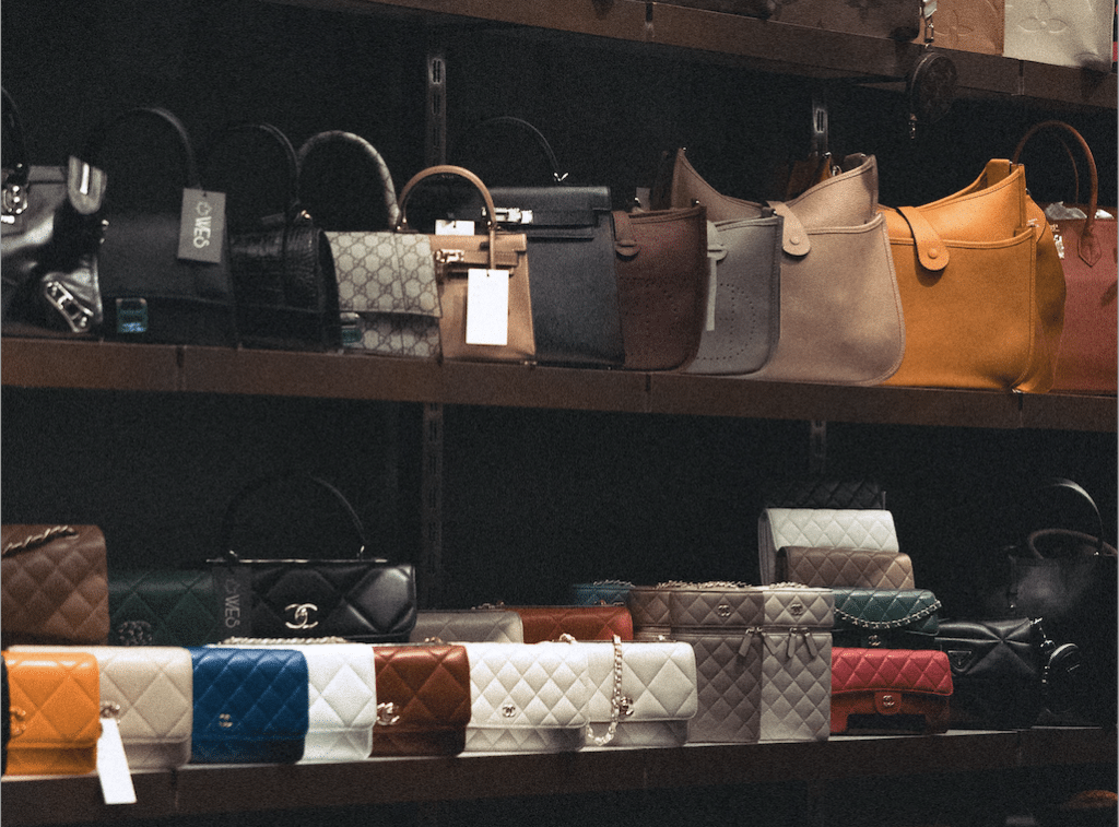 Designer handbags on shelves.