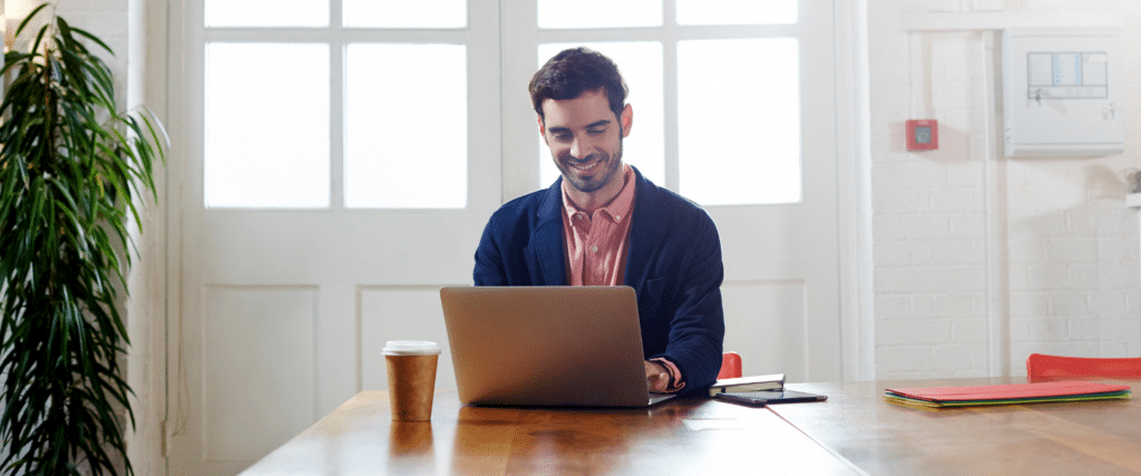 man sitting at a table with a laptop