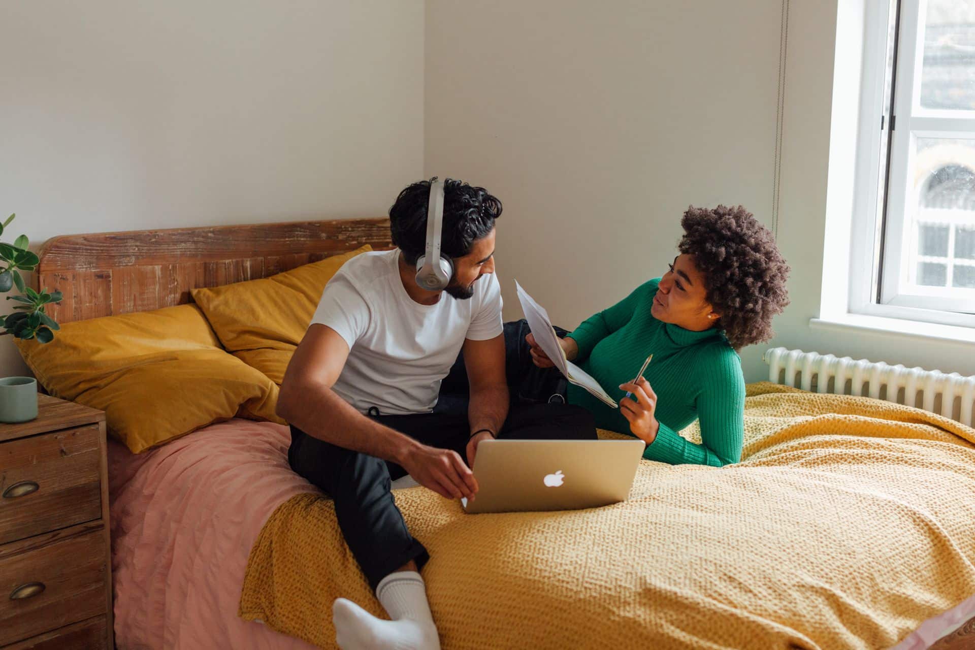 Young couple sitting on a bed talking